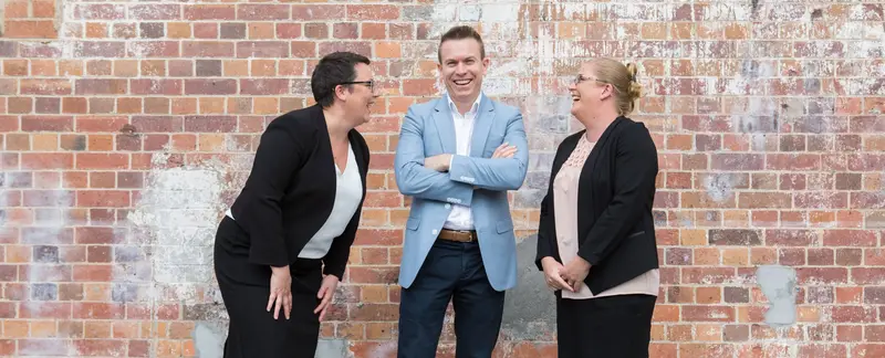 The BGM Family Lawyers team standing in front of a brick wall