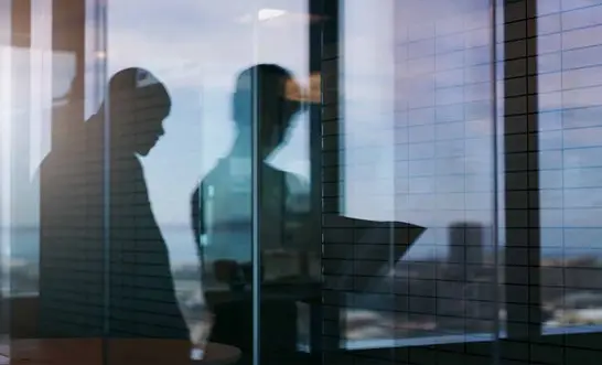 The Gilshenan & Luton Lawyers team in a glass-walled meeting room