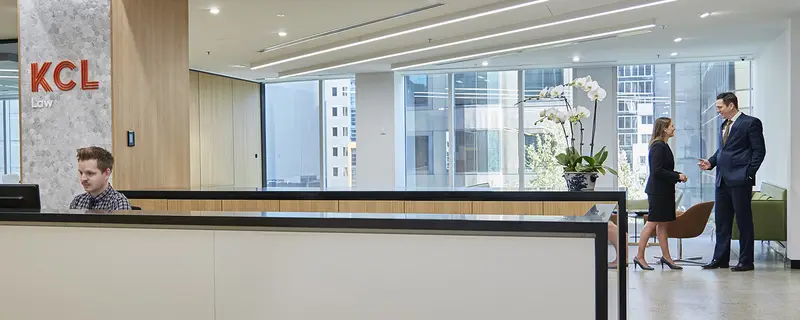 The KCL Law office reception area with a receptionist and two staff speaking