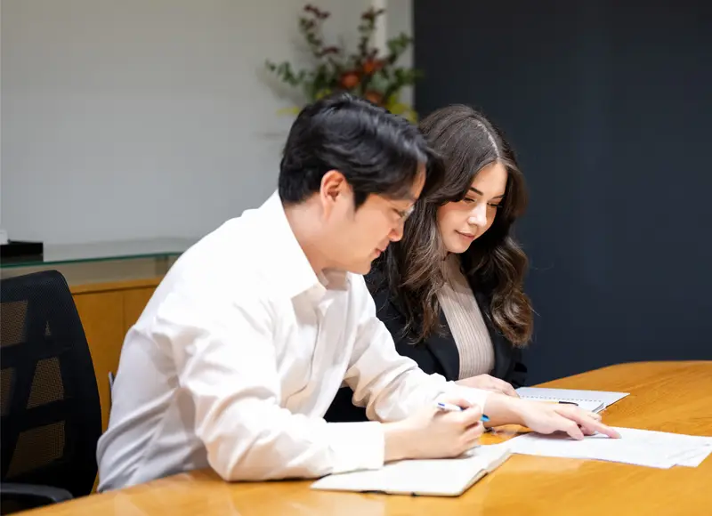 The Kindra Migration Lawyers team reviewing paperwork at a meeting table