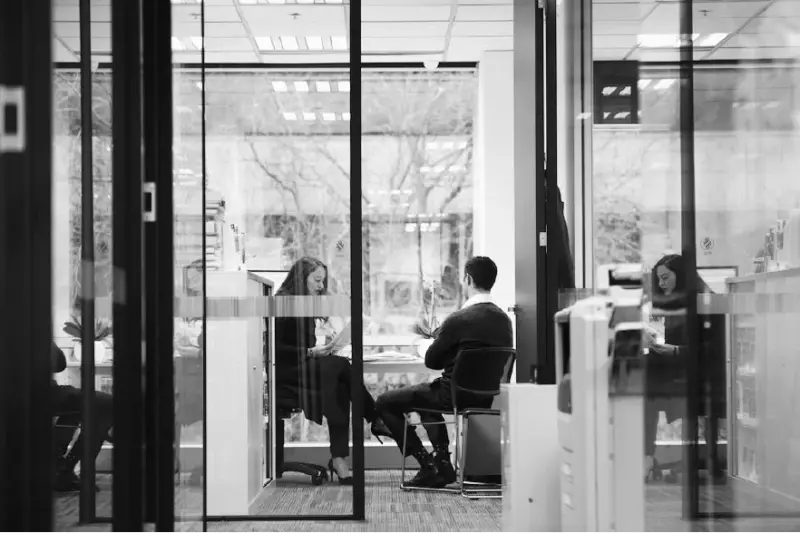The Tisher Liner FC Law team meeting in a glass-walled office